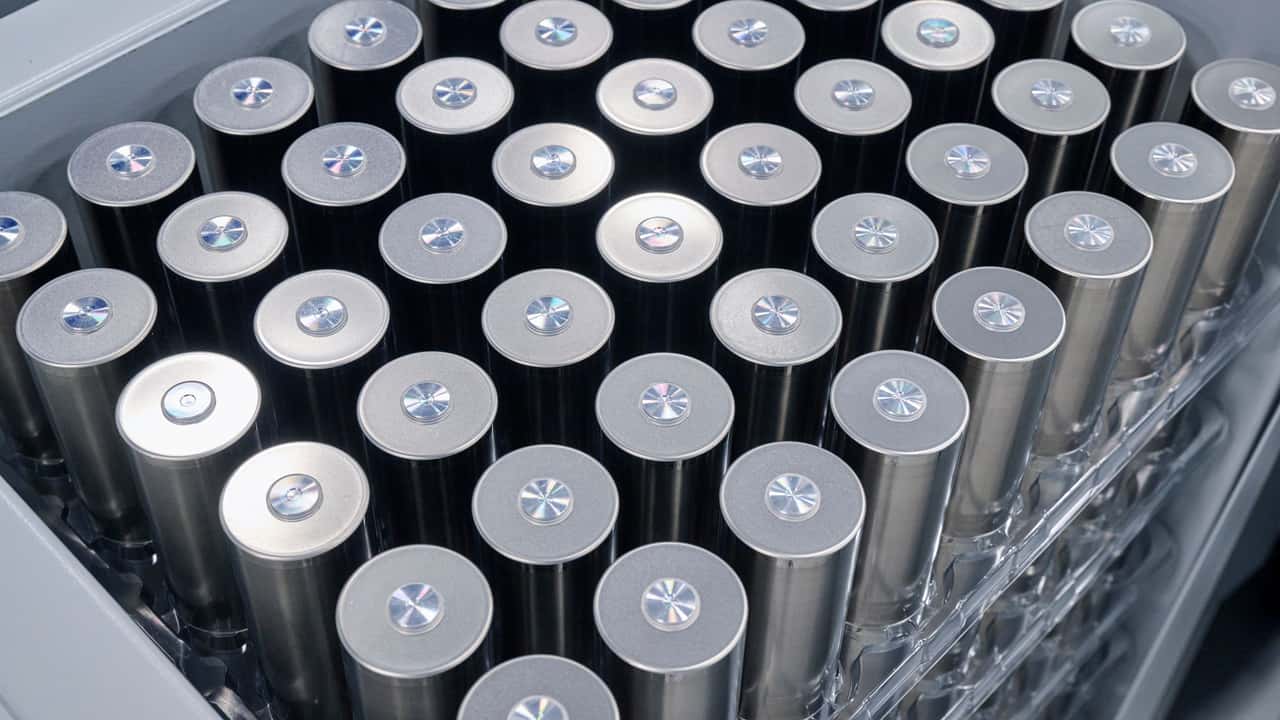 Numerous silver cylindrical batteries with star-like reflective caps, neatly arranged.
